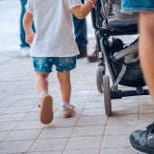 Imagen archivo de un niño caminando junto a su padre