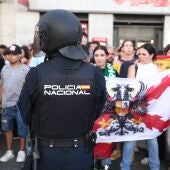 Varias personas con la bandera de España increpan a los acampados por la vivienda en la Puerta del Sol.