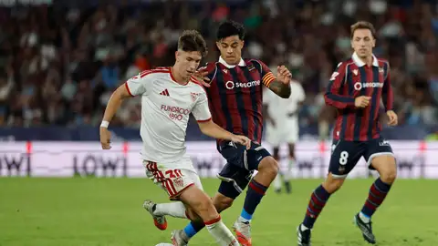 El delantero del Sevilla Miguel Sierra (i) juega un balón ante Roger Brugué (c), del Levante, durante el partido correspondiente a la octava jornada de LaLiga EA Sports que UD Levante y Sevilla FC disputaron en el estadio Ciutat de Valencia. El delantero del Sevilla Miguel Sierra (i) juega un balón ante Roger Brugué (c), del Levante, durante el partido correspondiente a la octava jornada de LaLiga EA Sports que UD Levante y Sevilla FC disputaron en el estadio Ciutat de Valencia.