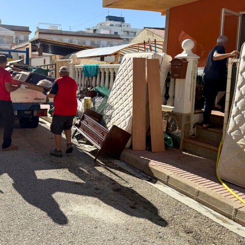Unos vecinos de Piles (Valencia) retiran pertenencias dañadas por el agua.