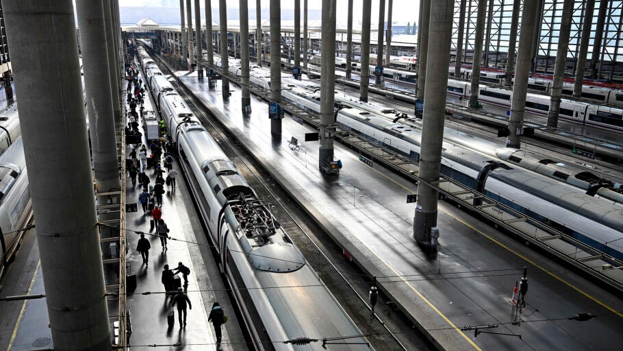 Varios pasajeros caminan por un and&eacute;n junto a un AVE en la Estaci&oacute;n de Atocha de Madrid este jueves.