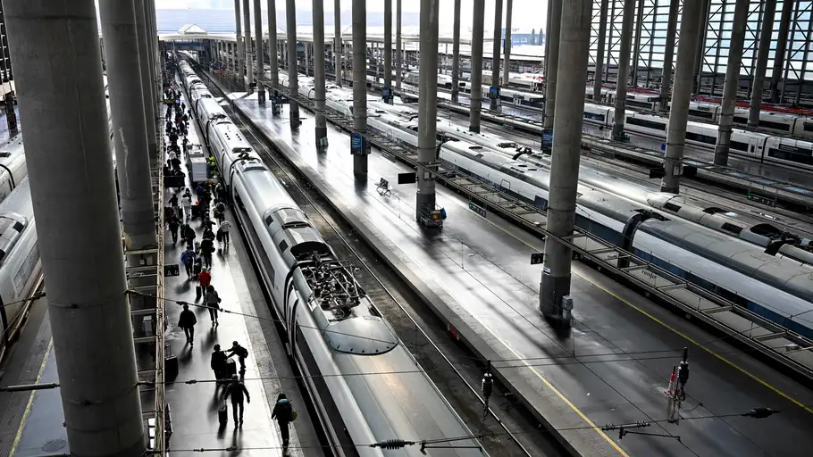 Varios pasajeros caminan por un andén junto a un AVE en la Estación de Atocha de Madrid este jueves. Varios pasajeros caminan por un andén junto a un AVE en la Estación de Atocha de Madrid este jueves.