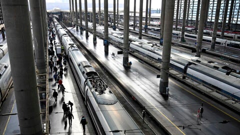 Varios pasajeros caminan por un and&eacute;n junto a un AVE en la Estaci&oacute;n de Atocha de Madrid este jueves.