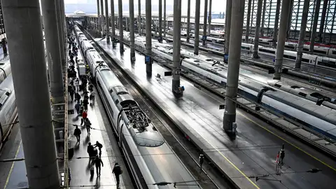 Varios pasajeros caminan por un andén junto a un AVE en la Estación de Atocha de Madrid este jueves. Varios pasajeros caminan por un andén junto a un AVE en la Estación de Atocha de Madrid este jueves.