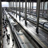 Varios pasajeros caminan por un andén junto a un AVE en la Estación de Atocha de Madrid este jueves.
