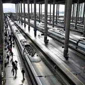 Varios pasajeros caminan por un andén junto a un AVE en la Estación de Atocha de Madrid este jueves. Varios pasajeros caminan por un andén junto a un AVE en la Estación de Atocha de Madrid este jueves.