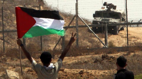 Ondea una bandera palestina ante las tropas israel&iacute;es