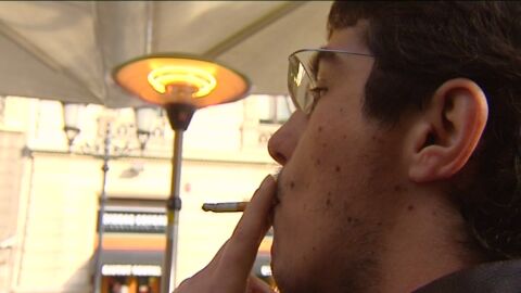 Fumando en una terraza con una estufa