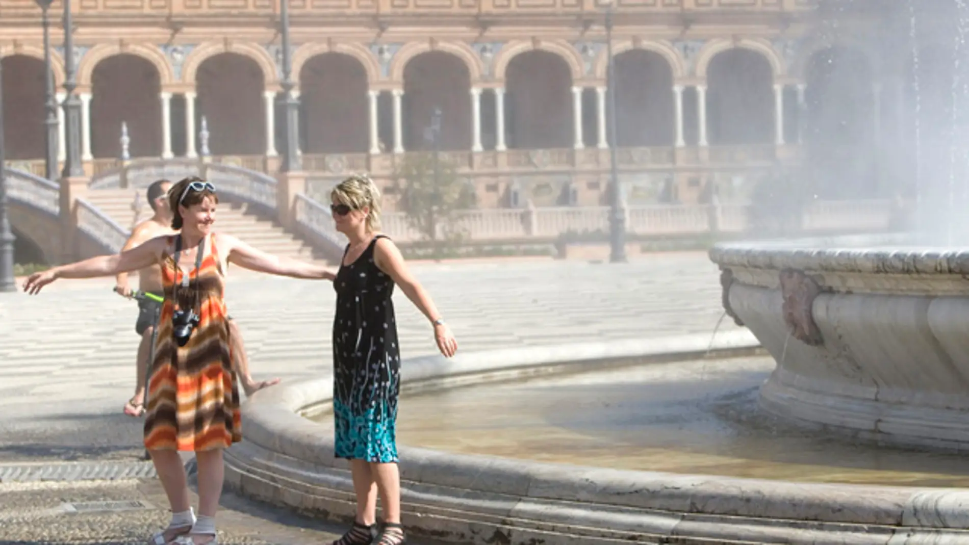 Turistas refrescándose en la Plaza de España