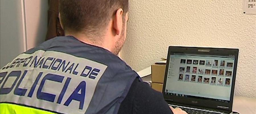 Un policía comprueba archivos en un ordenador Un policía comprueba archivos en un ordenador