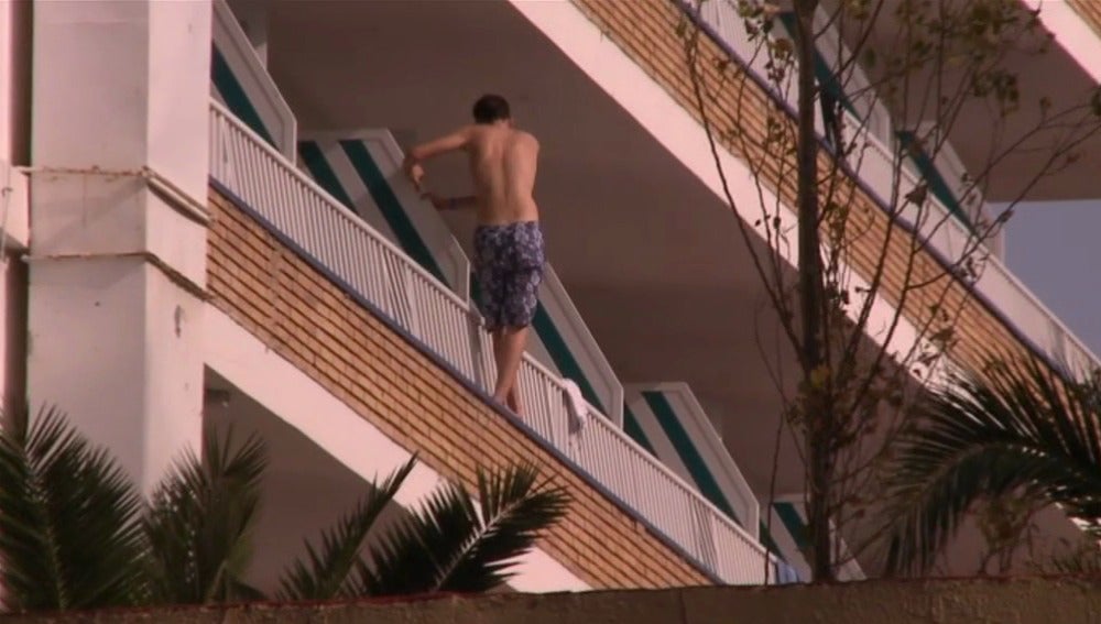 Un turista intentando saltar de un balcón a otro.