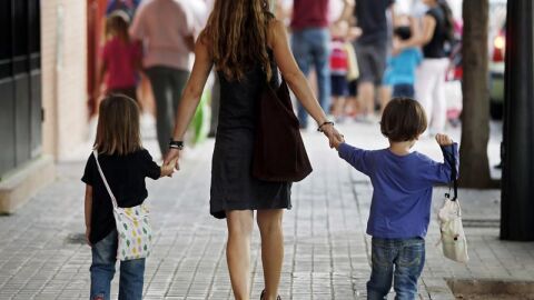  Una madre se dirige con sus hijos al colegio 