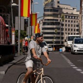 Un ciudadano conduce su bici por la Gran Vía