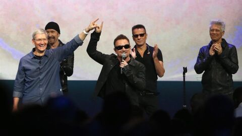 Bono, l&iacute;der de U2, levanta la mano al director ejecutivo de Apple, Tim Cook