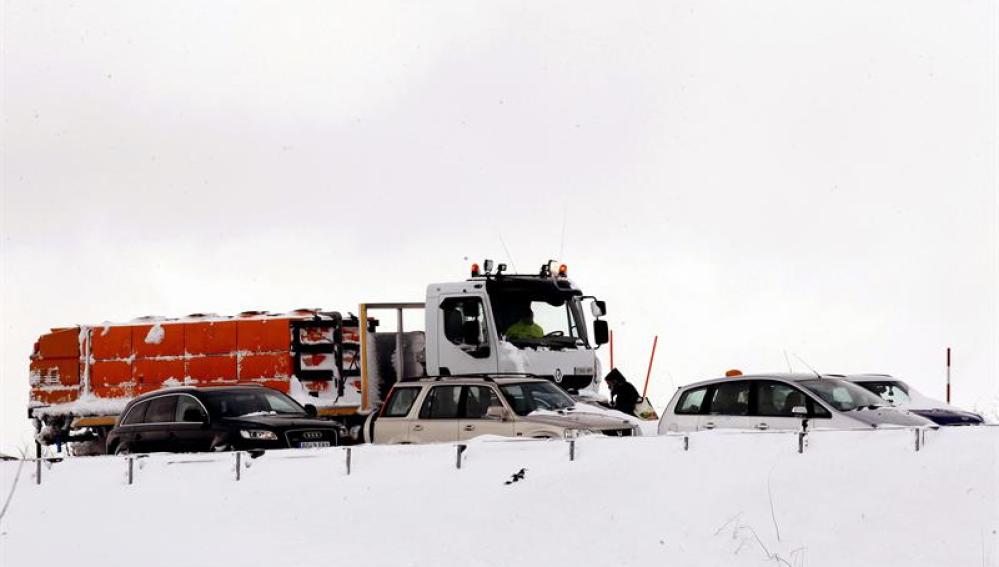 Una máquina quitanieves junto a varios vehículos atrapados en la A-67
