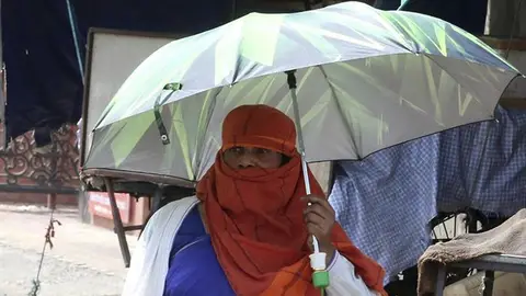 Una mujer se protege del sol en Bhopal, India Una mujer se protege del sol en Bhopal, India