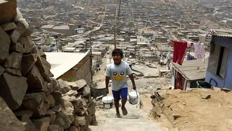 Niño cargando agua en Perú - Contraparte Un niño recoge agua de un recipiente en el barrio de chabolas de Pamplona Alta, en el distrito de San Juan de Miraflores de Lima. El rápido crecimiento en América Latina durante la última década ha dejado a uno de cada cinco habitantes de la región con menos de 4 dólares por día, según el Banco Mundial.