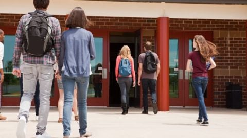 Una pareja de adolescentes entrando al instituto