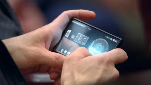 LG de Tony Stark en 'Iron Man 2' es un smartphone muy moderno y de tecnología punta cuyo sistema y material aún estan investigando en la realidad, pero resultaría perfecto para el controlador de Grey. LG de Tony Stark en 'Iron Man 2' es un smartphone muy moderno y de tecnología punta cuyo sistema y material aún estan investigando en la realidad, pero resultaría perfecto para el controlador de Grey.