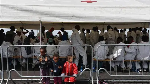 Un grupo de inmigrantes descansa bajo una carpa de la Cruz Roja Un grupo de inmigrantes descansa bajo una carpa de la Cruz Roja