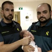 Imagen de los dos Guardias Civiles con el bebé rescatado