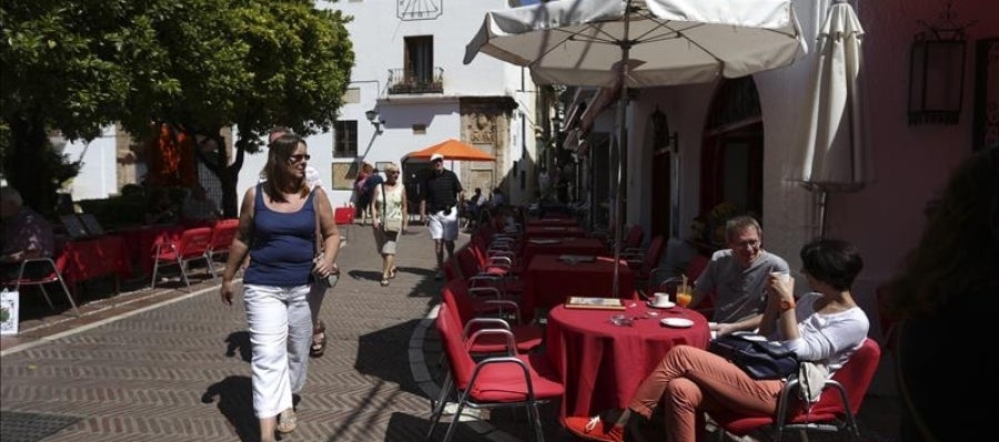 Algunos turistas se refrescan sentados en una terraza de Marbella Algunos turistas se refrescan sentados en una terraza de Marbella