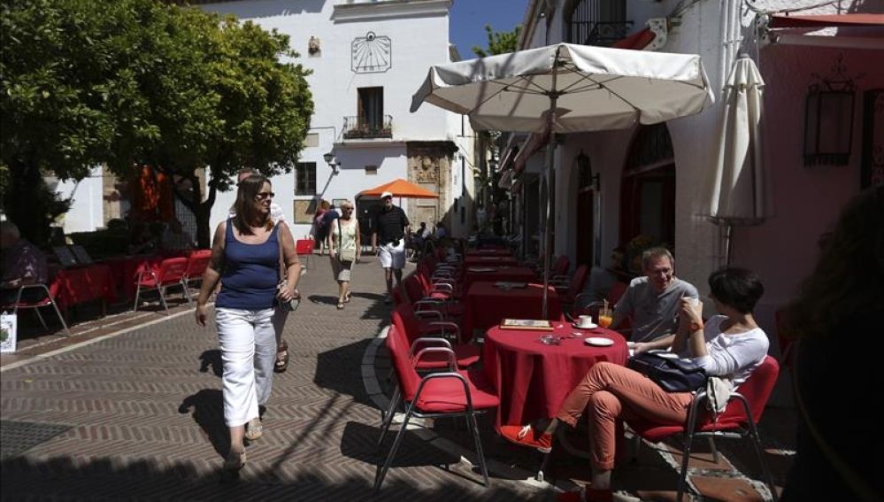 Algunos turistas se refrescan sentados en una terraza de Marbella