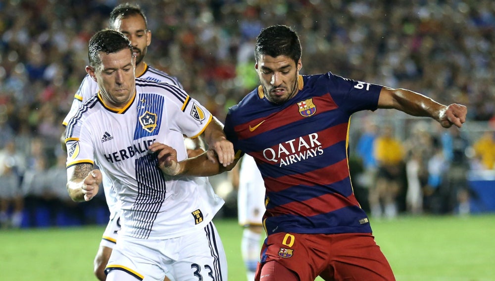 Luis Suárez disputa un balón con un jugador de Los Ángeles Galaxy