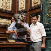 El primer teniente de alcalde y un operario retiran el busto del Rey Juan Carlos