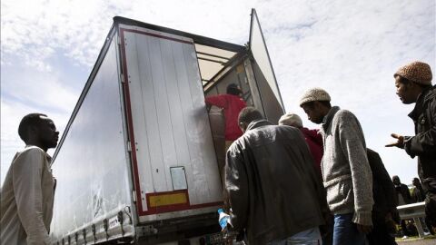 Inmigrantes suben a un cami&oacute;n para acceder al t&uacute;nel del Canal de la Mancha