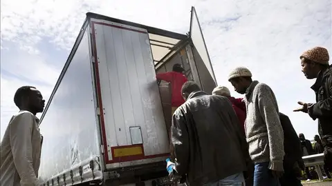 Inmigrantes suben a un camión para acceder al túnel del Canal de la Mancha Inmigrantes suben a un camión para acceder al túnel del Canal de la Mancha