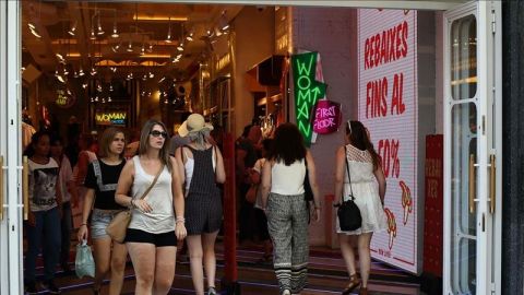 Varias personas entrando y saliendo de una tienda en &eacute;poca de rebajas