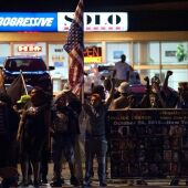 Manifestantes protestan con pancartas y banderas, para conmemorar el primer año de la muerte del adolescente afroamericano Michael Brown Jr. en Ferguson, Missouri (EEUU).