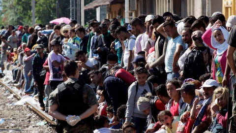 Las fuerzas de seguridad vigilan a los refugiados en la estaci&oacute;n de tren en Macedonia