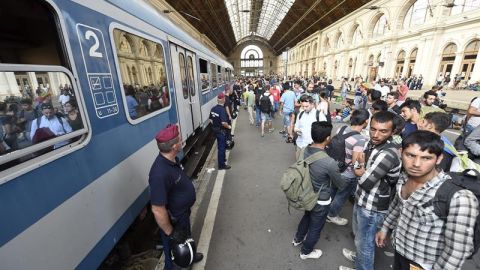  Inmigrantes esperan para subir a un tren en la estaci&oacute;n Keleti de Budapest.