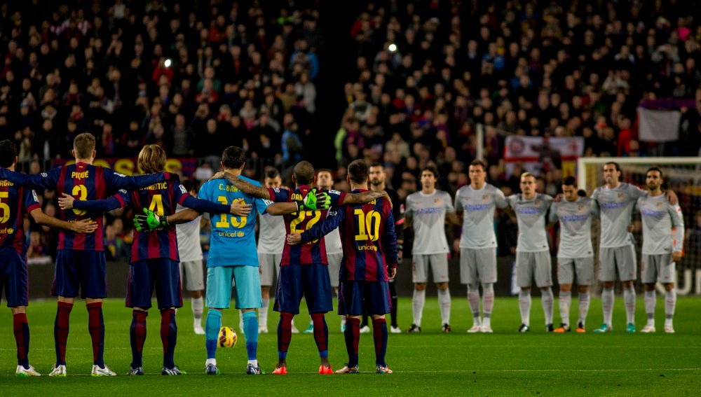 Jugadores del Atlético de Madrid y FC Barcelona, guardando un minuto de silencio