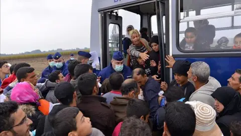 Inmigrantes suben a un autobús en Röszke Inmigrantes suben a un autobús en Röszke