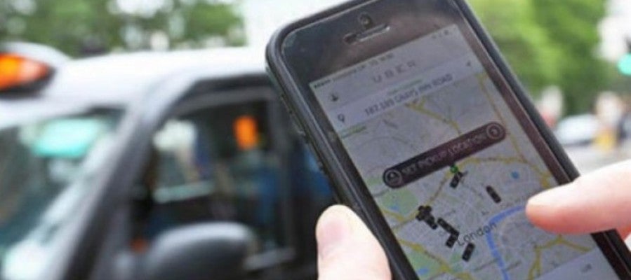 Un usuario utiliza la aplicación Uber Un usuario utiliza la aplicación Uber