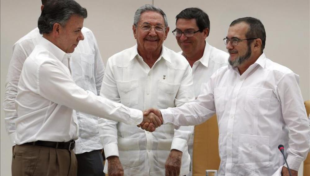 Juan Manuel Santos y Timochenko en presencia de Castro