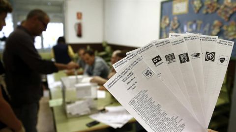 Una persona muestra las papeletas de los diferentes partidos que concurren a las elecciones al Parlamento Catal&aacute;n. 