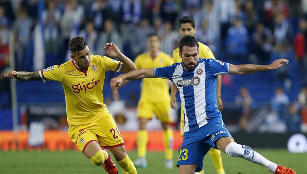 El defensa del RCD Espanyol, Anaitz Arbilla, intenta controlar el balón ante el delantero paraguayo del Sporting, Antonio Sanabria