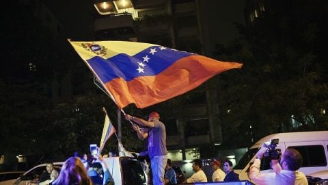 Un hombre con una bandera de Venezuela tras conocer los resultados electorales