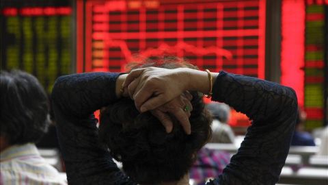 Una mujer comprueba la evolución de la bolsa de Shangái (China) Una mujer comprueba la evolución de la bolsa de Shangái (China)