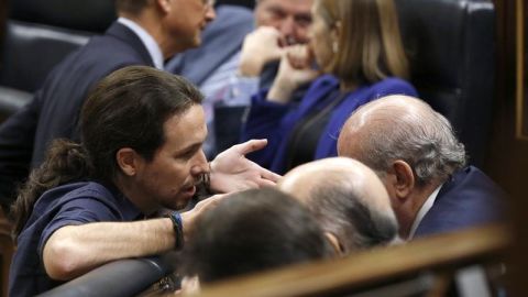 El l&iacute;der de Podemos, Pablo Iglesias, conversa con el ministro en funciones del Interior, Jorge Fern&aacute;ndez D&iacute;az