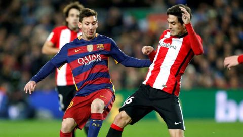 El defensa del Athletic Xabier Etxeita pelea un bal&oacute;n con el delantero argentino del Barcelona Lionel Messi