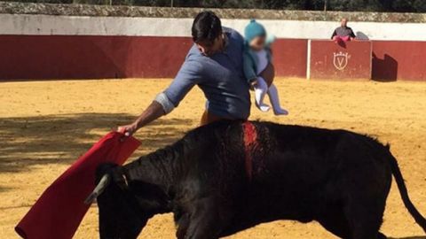 Foto de Fran Rivera toreando una vaquilla con su hija peque&ntilde;a en brazos