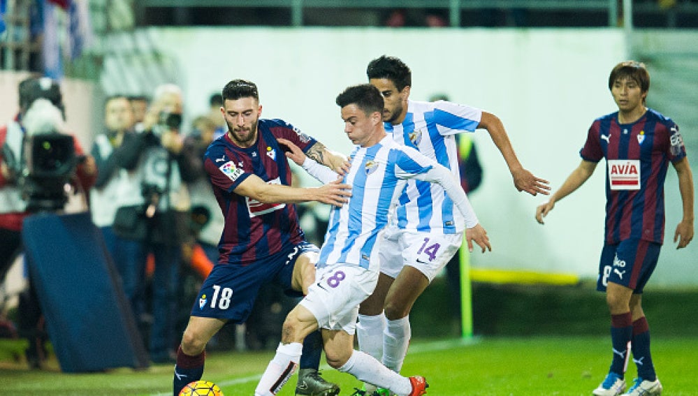 Borja Gonzalez del Eibar lucha por el balón con Juanpi del Málaga CF 