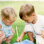 Imagen de dos niños jugando en el césped