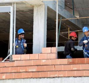 Tres obreros trabajan en la construcción de una vivienda Tres obreros trabajan en la construcción de una vivienda