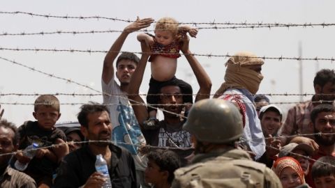 Varios refugiados aguardan en la frontera